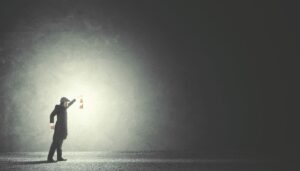 man shining light in the dark